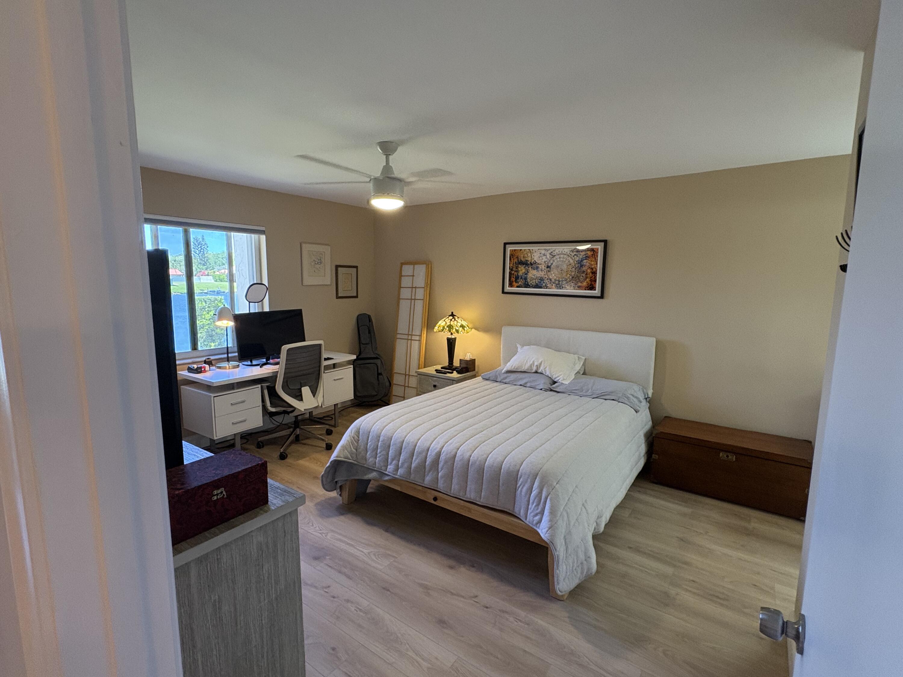 1680 Northwest 20th Avenue, Unit 102 Delray Beach, FL 33445 - Photo 11 of 17 a bedroom with a bed and wooden floor