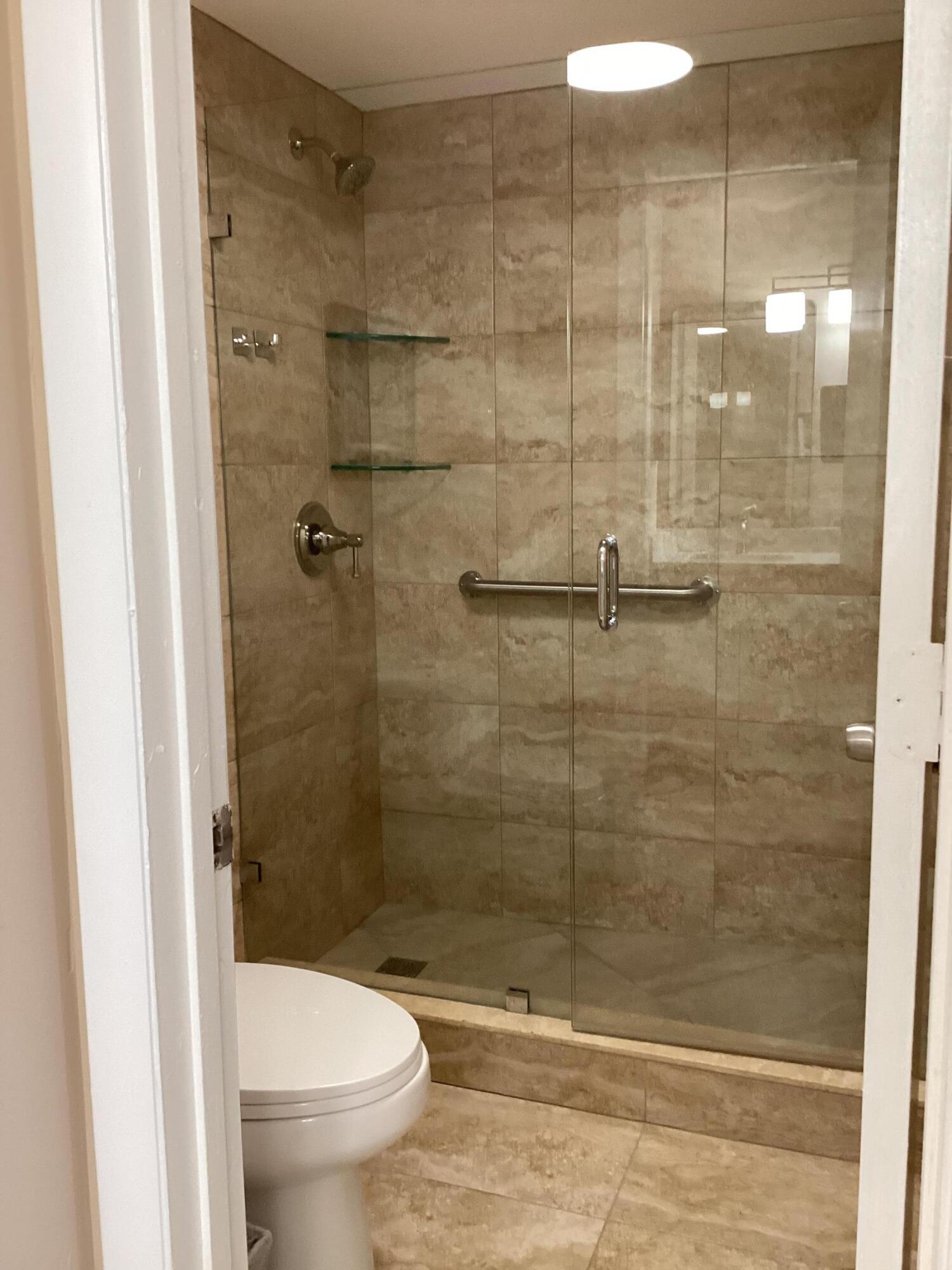 1680 Northwest 20th Avenue, Unit 102 Delray Beach, FL 33445 - Photo 12 of 17 a bathroom with a shower and a toilet