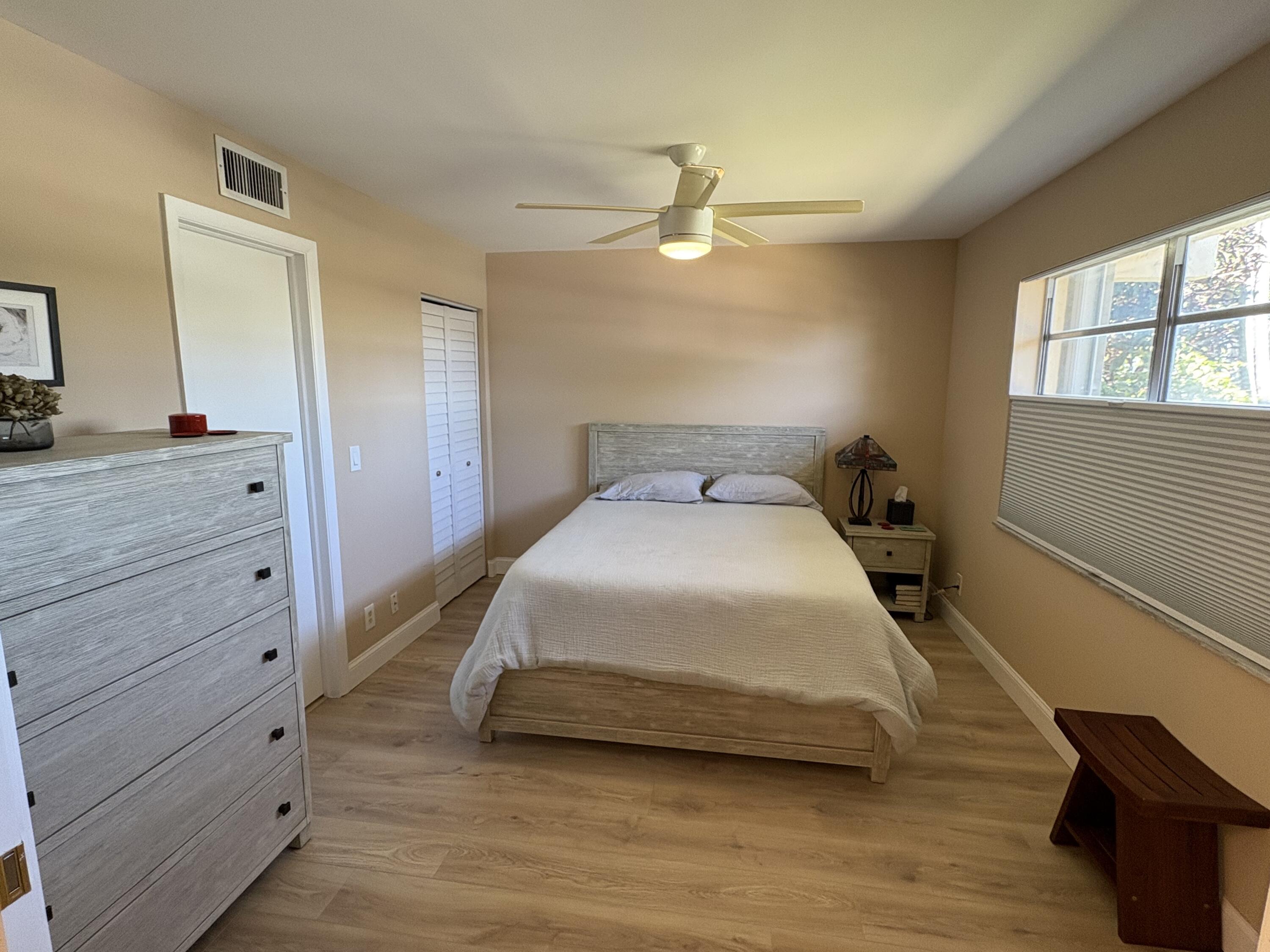 1680 Northwest 20th Avenue, Unit 102 Delray Beach, FL 33445 - Photo 14 of 17 a bedroom with a bed and a dresser