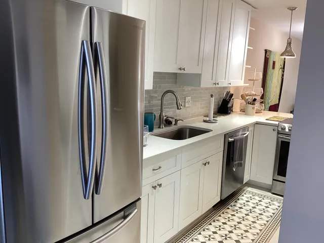 a kitchen with stainless steel appliances a refrigerator sink and cabinets
