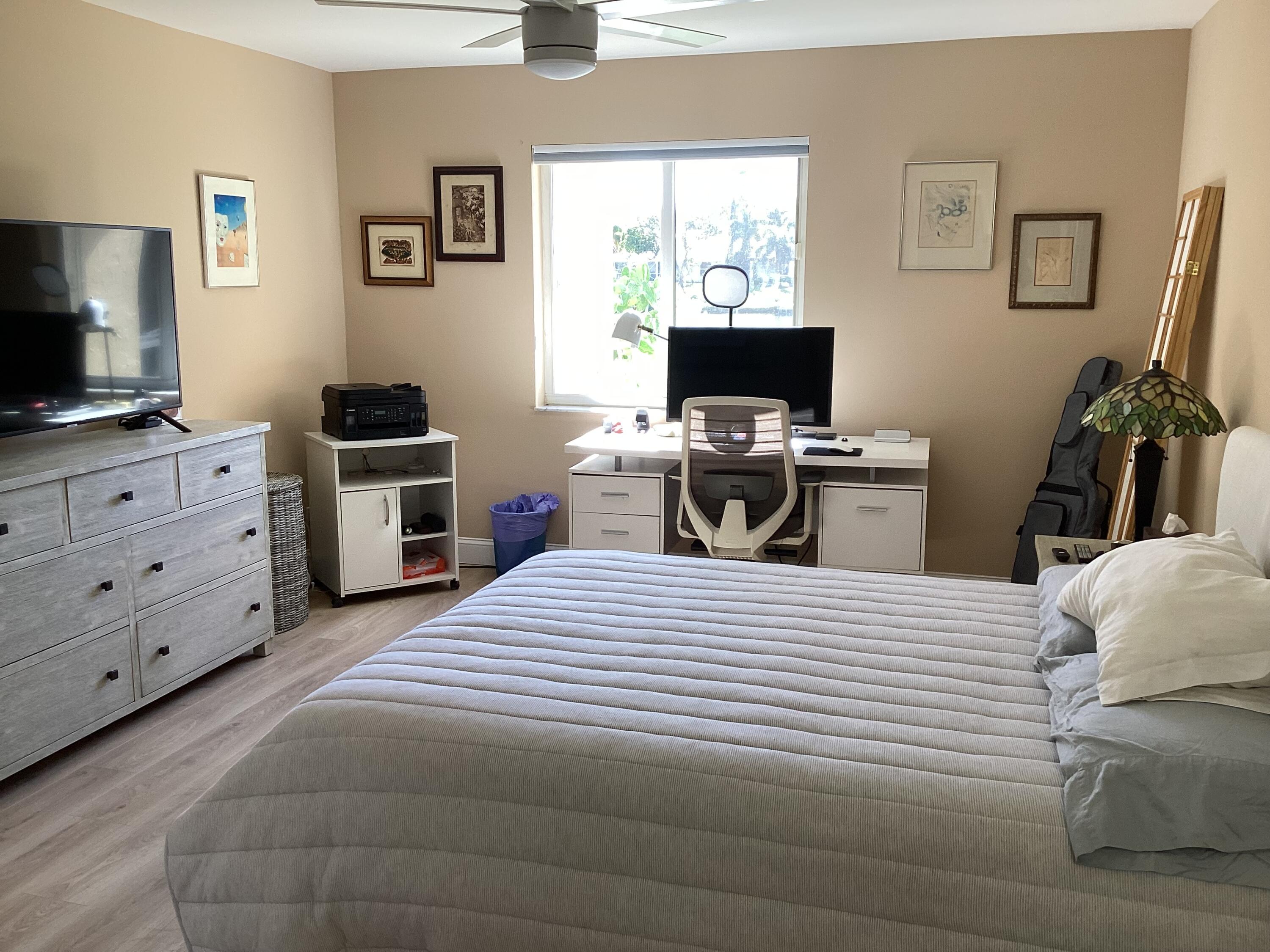 1680 Northwest 20th Avenue, Unit 102 Delray Beach, FL 33445 - Photo 10 of 17 a bedroom with a bed and a flat screen tv