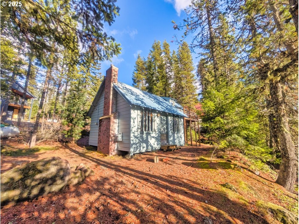 a view of house with yard and trees in the background