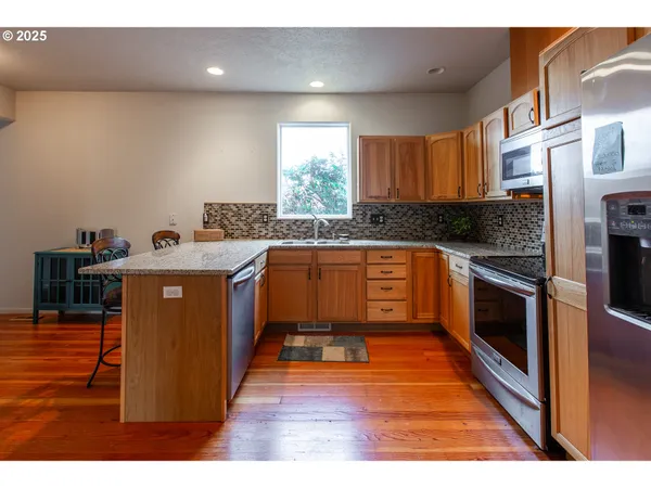 a kitchen with stainless steel appliances granite countertop a stove a sink and a refrigerator