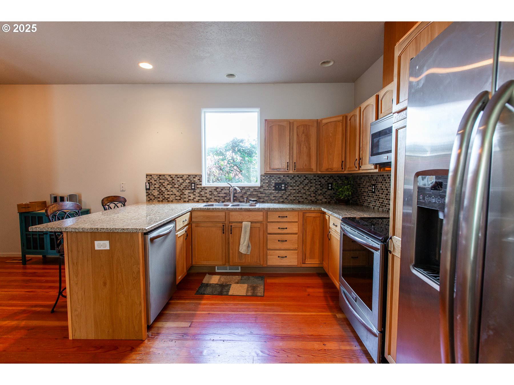 6964 Bluebelle Way Springfield, OR 97478 - Photo 10 of 35 a kitchen with stainless steel appliances granite countertop a stove a sink and a refrigerator
