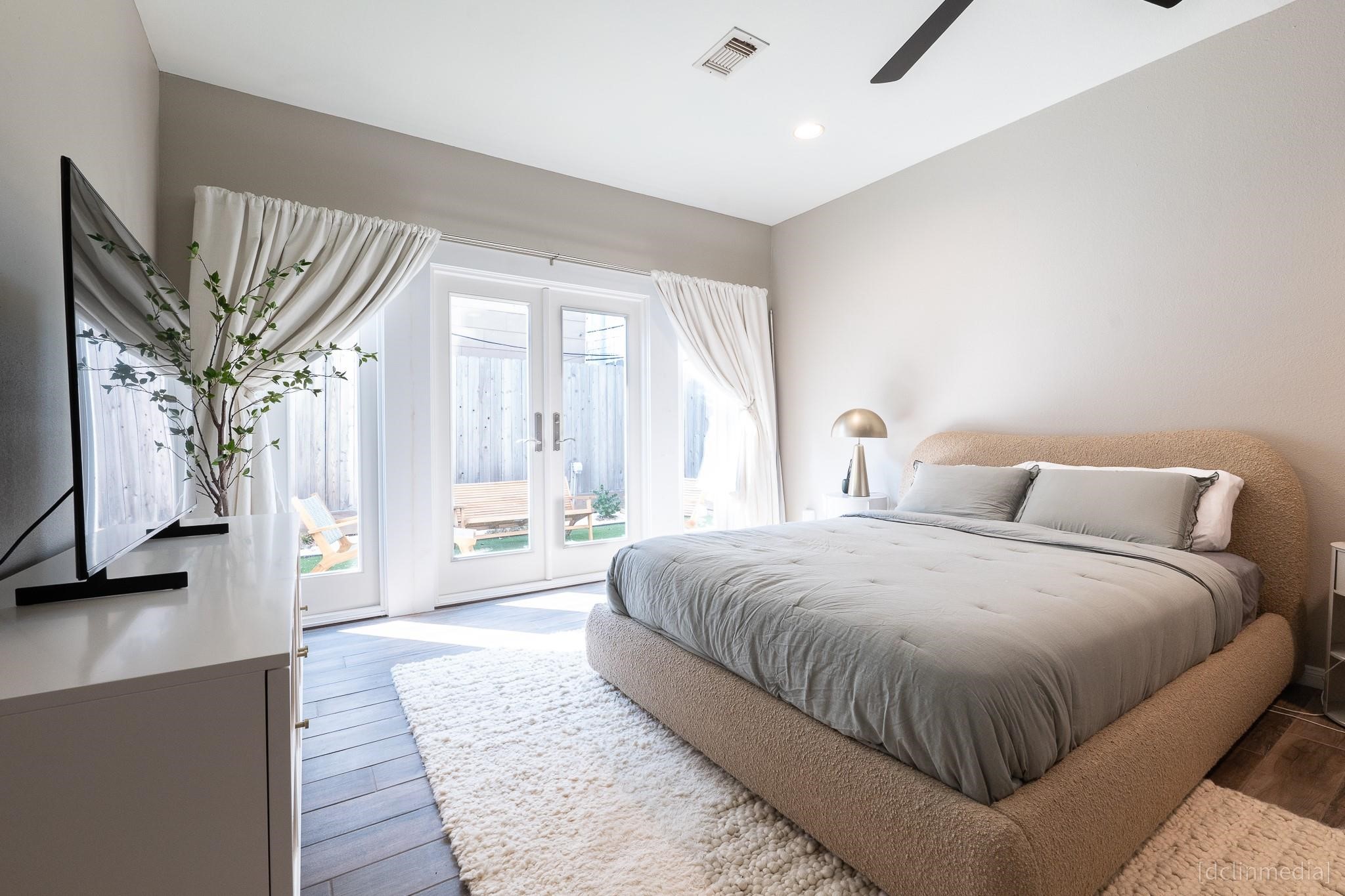2002 Norfolk Street, Unit A Houston, TX 77098 - Photo 23 of 35 a spacious bedroom with a large bed and a chandelier