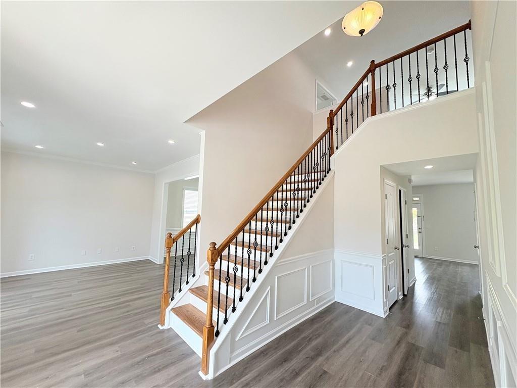 4195 Settlers Grove Road Cumming, GA 30028 - Photo 3 of 38 a view of staircase with wooden floor and a chandelier