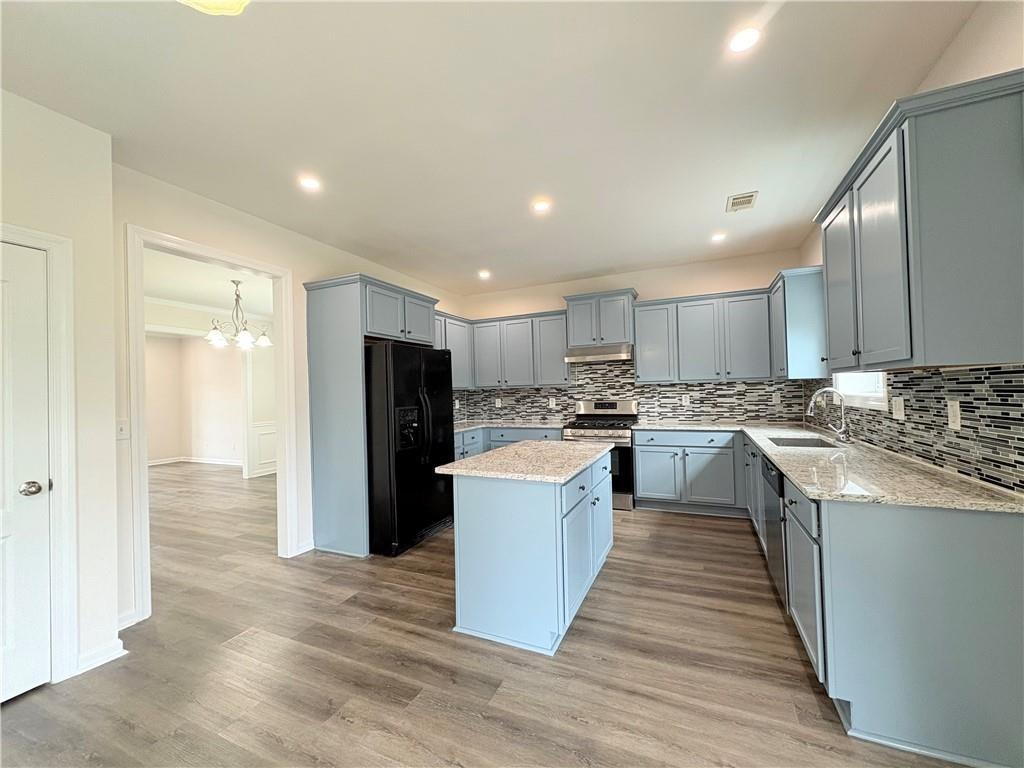 4195 Settlers Grove Road Cumming, GA 30028 - Photo 8 of 38 a large kitchen with stainless steel appliances lots of counter top space and cabinets