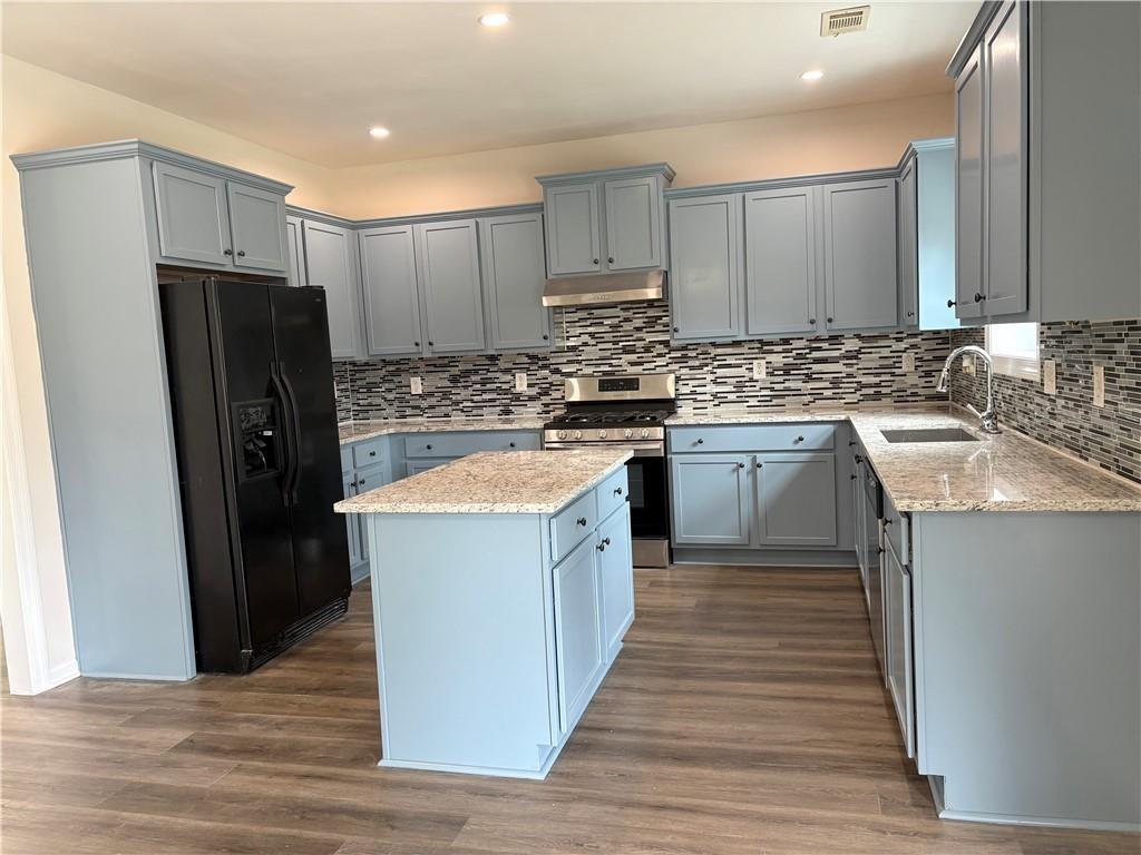 4195 Settlers Grove Road Cumming, GA 30028 - Photo 9 of 38 a kitchen with stainless steel appliances granite countertop a stove top oven a refrigerator and a sink