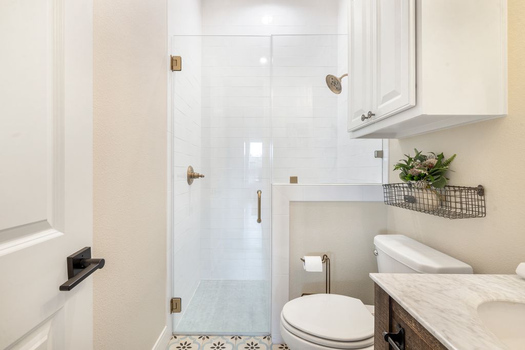 7650 Rolling Creek Road Burton, TX 77835 - Photo 14 of 22 a white toilet sitting next to a bathroom sink