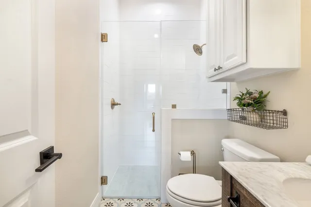 a view of a bedroom with wooden floor & a ceiling fan