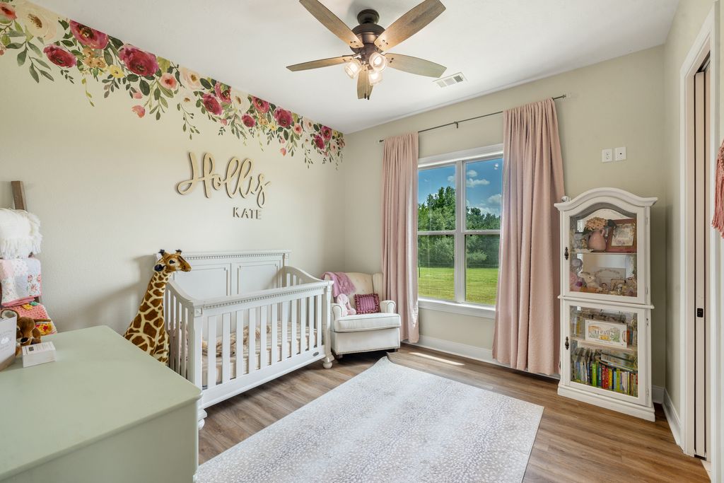 7650 Rolling Creek Road Burton, TX 77835 - Photo 15 of 22 a view of a bedroom with wooden floor & a ceiling fan