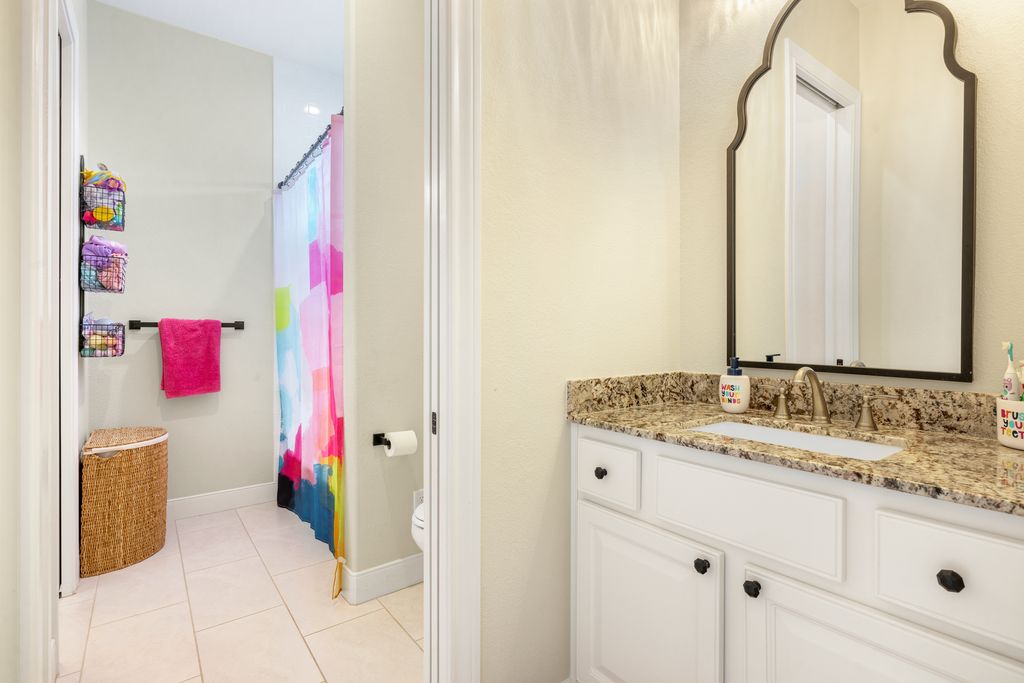 7650 Rolling Creek Road Burton, TX 77835 - Photo 16 of 22 a bathroom with a granite countertop sink and a mirror