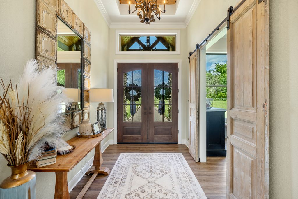7650 Rolling Creek Road Burton, TX 77835 - Photo 5 of 22 Large foyer with tray ceiling feature to receive friends and family with antique doors that lead to the office as a thoughtful design feature--interior view of the double door entrance