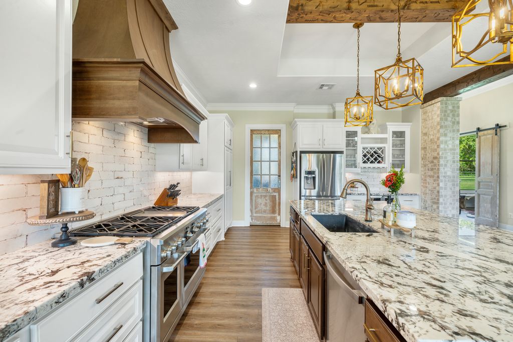 7650 Rolling Creek Road Burton, TX 77835 - Photo 7 of 22 a kitchen with stainless steel appliances granite countertop a sink and stove