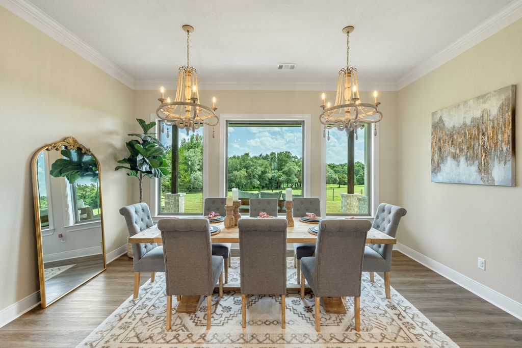 7650 Rolling Creek Road Burton, TX 77835 - Photo 9 of 22 a view of a dining room with furniture a chandelier and wooden floor