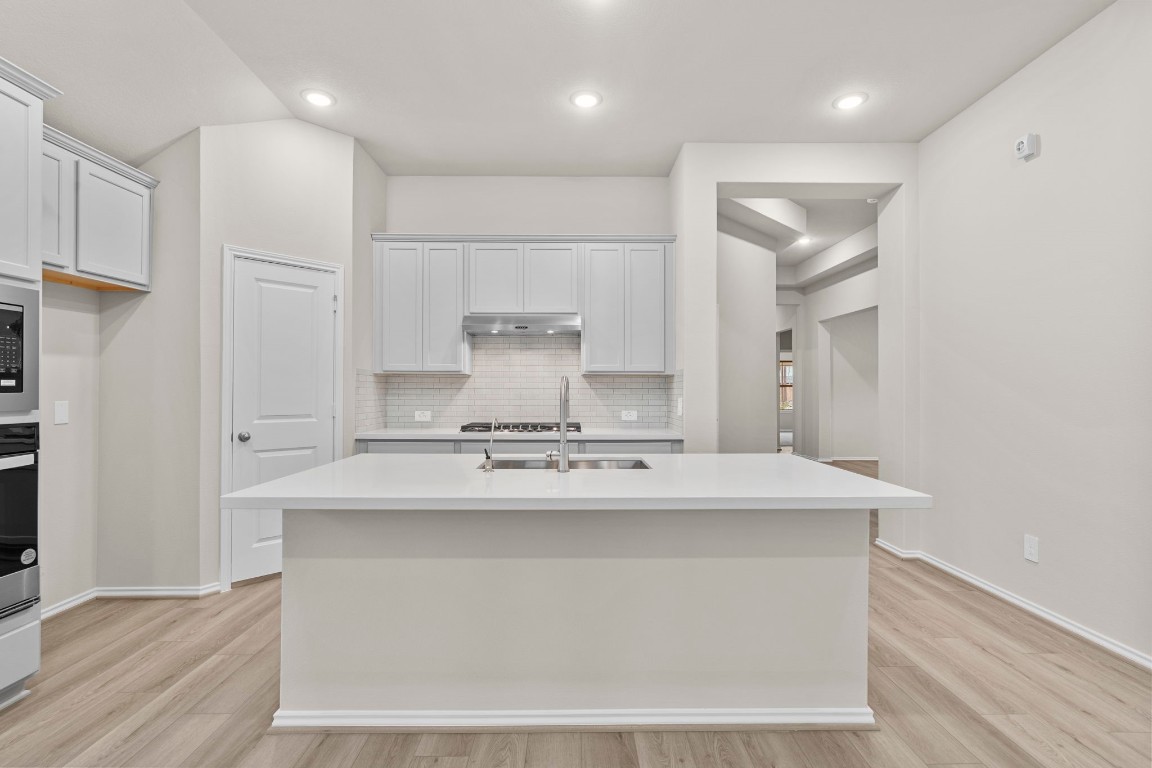 9526 Sierra Crest Lane Porter, TX 77365 - Photo 3 of 39 a kitchen with kitchen island a sink a stove and a refrigerator