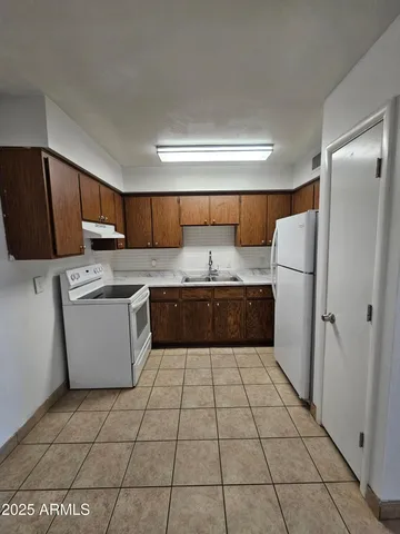 a kitchen with a cabinets and a refrigerator