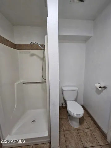 a bathroom with a toilet and a shower