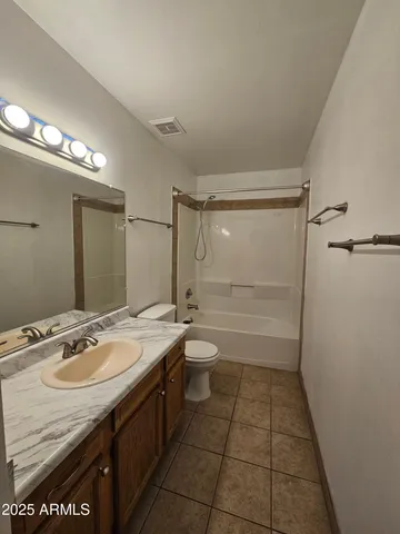 a bathroom with a granite countertop sink a toilet a mirror and shower