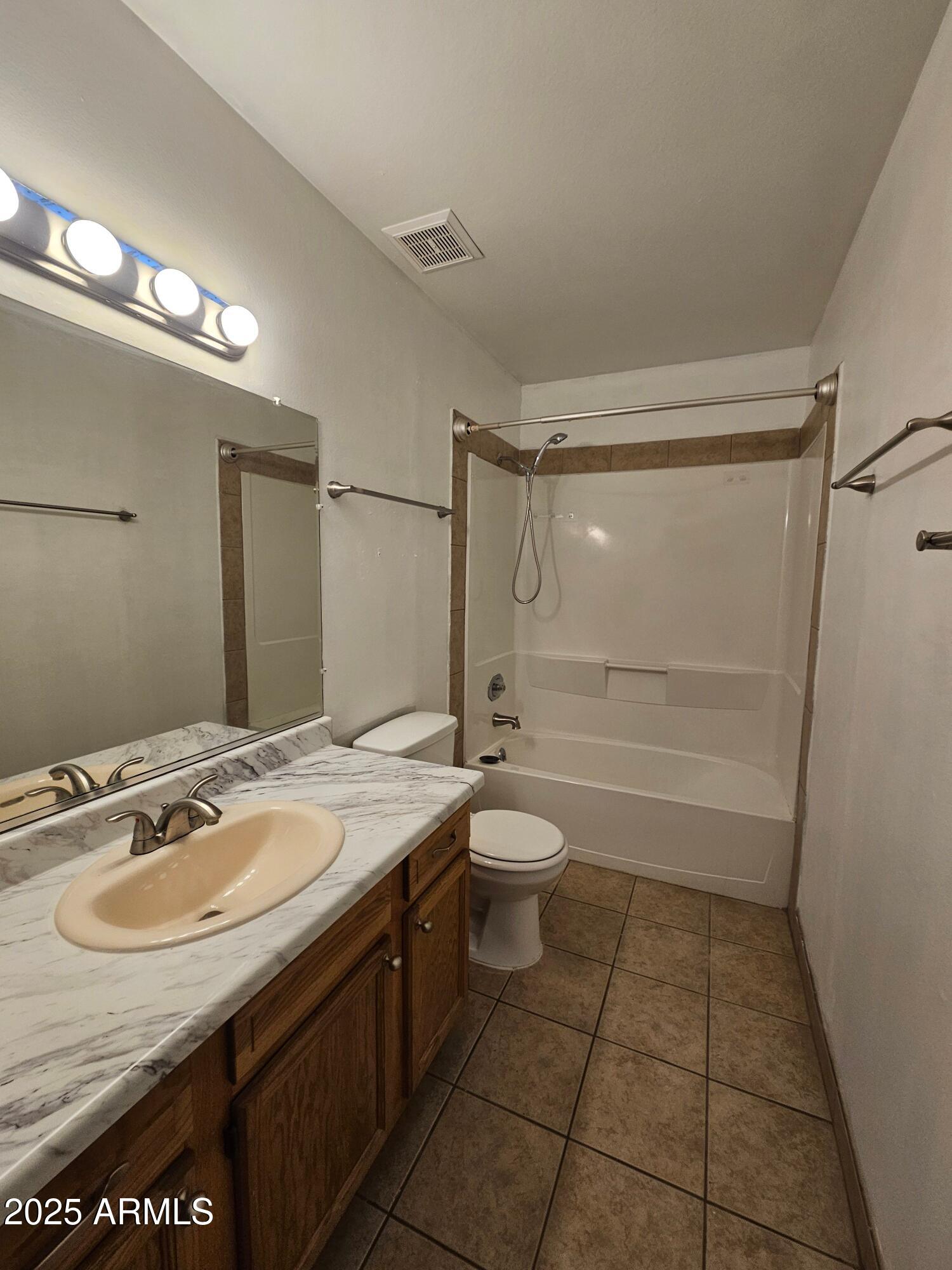 180 North Apache Road, Unit 24 Buckeye, AZ 85326 - Photo 29 of 32 a bathroom with a granite countertop sink a toilet a mirror and shower