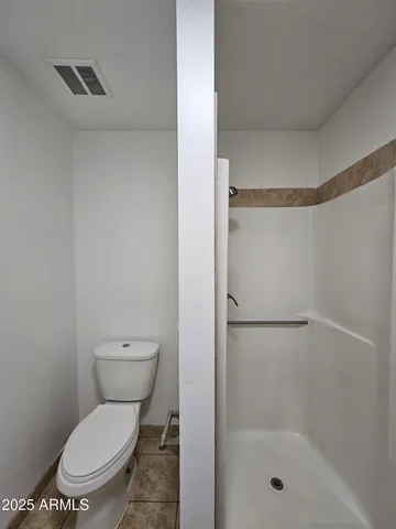 a white toilet sitting next to a bath tub