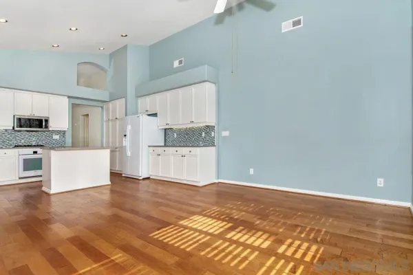 a view of kitchen with granite countertop cabinets and refrigerator