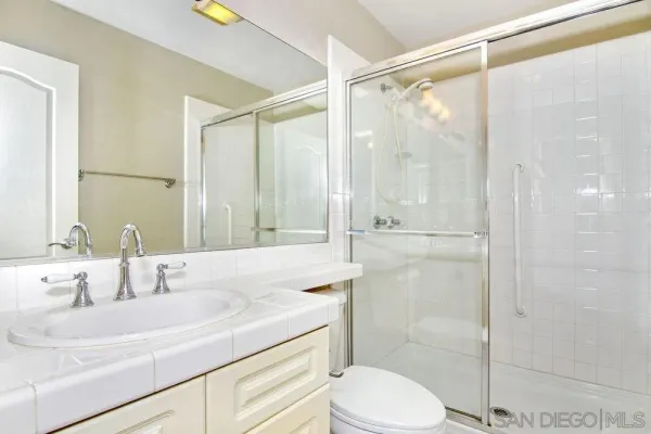 a bathroom with a granite countertop sink toilet and shower