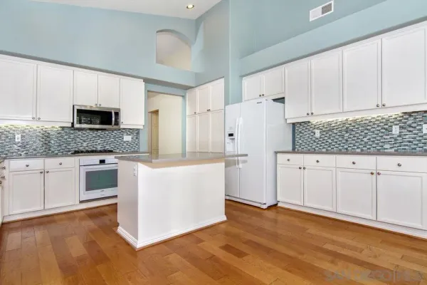a kitchen with granite countertop white cabinets and stainless steel appliances