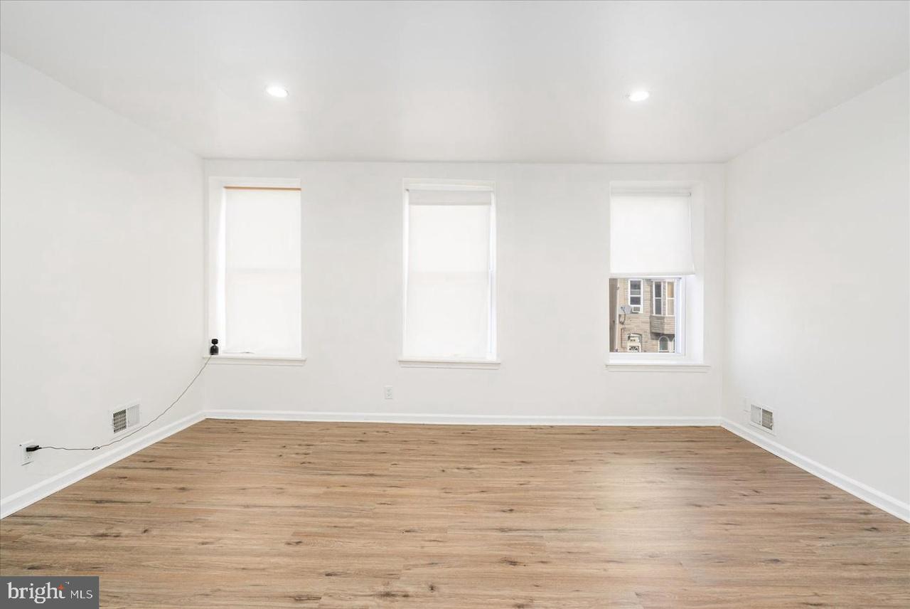 1715 West Lexington Street, Unit 2 Baltimore, MD 21223 - Photo 1 of 21 an empty room with wooden floor and windows