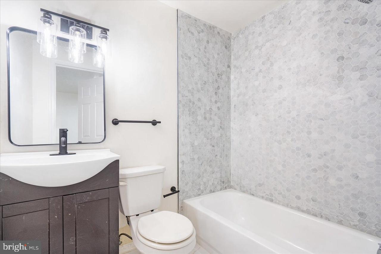 1715 West Lexington Street, Unit 2 Baltimore, MD 21223 - Photo 12 of 21 a bathroom with a sink a toilet and shower