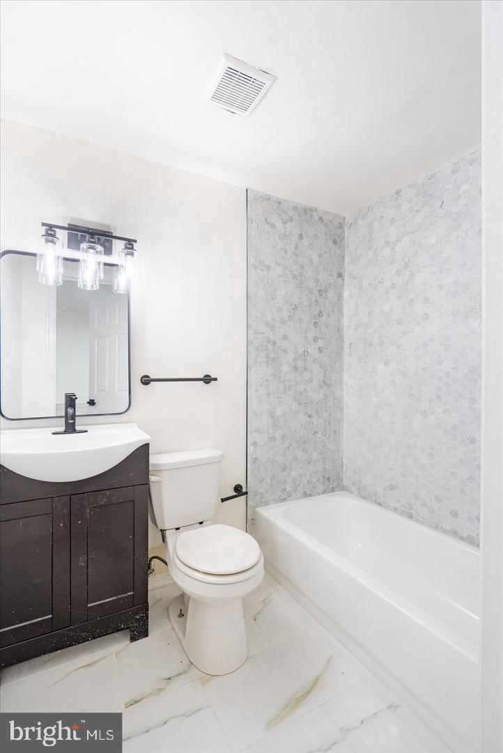 1715 West Lexington Street, Unit 2 Baltimore, MD 21223 - Photo 13 of 21 a bathroom with a sink a toilet and shower