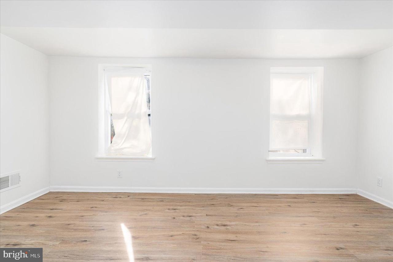 1715 West Lexington Street, Unit 2 Baltimore, MD 21223 - Photo 14 of 21 a view of an empty room with wooden floor and a window