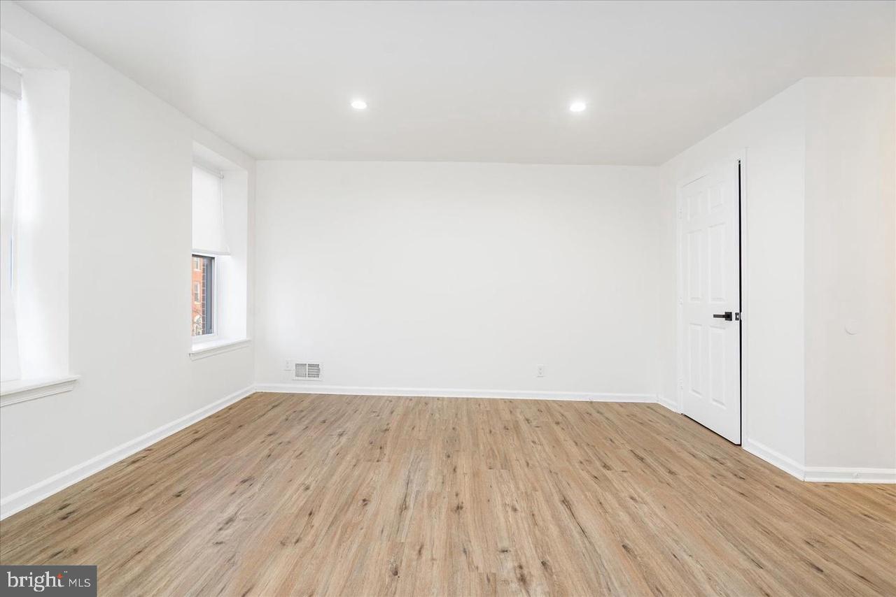 1715 West Lexington Street, Unit 2 Baltimore, MD 21223 - Photo 18 of 21 an empty room with wooden floor and windows