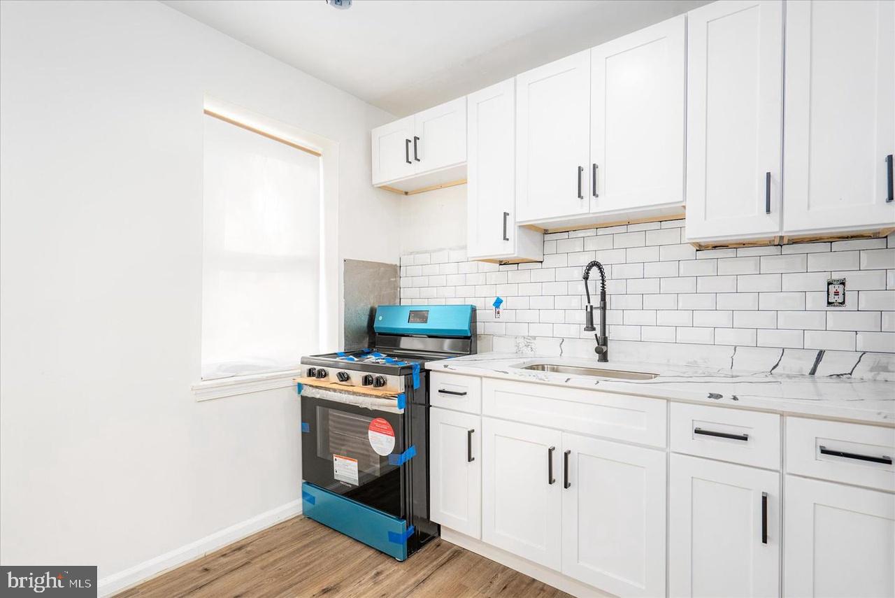 1715 West Lexington Street, Unit 2 Baltimore, MD 21223 - Photo 6 of 21 a kitchen with cabinets appliances a sink and a counter top