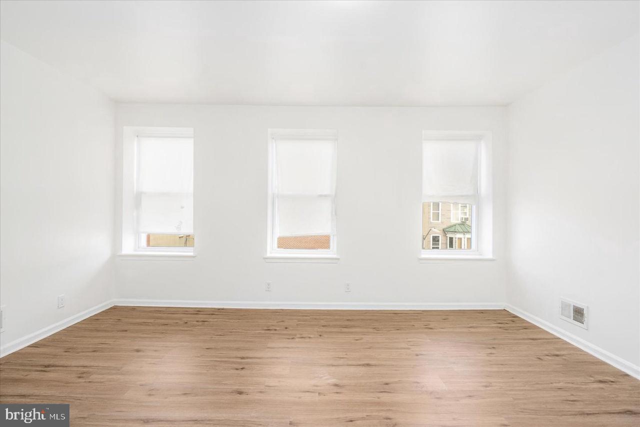 1715 West Lexington Street, Unit 2 Baltimore, MD 21223 - Photo 10 of 21 a view of an empty room with wooden floor and a window