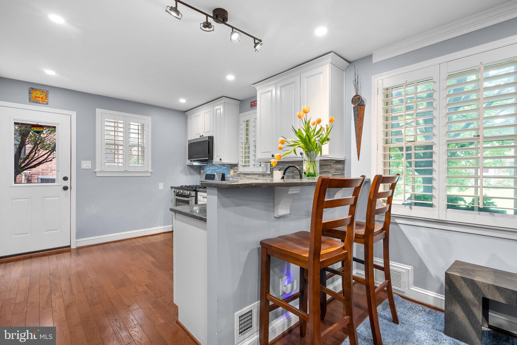 9911 Edgehill Lane Silver Spring, MD 20901 - Photo 9 of 45 a kitchen with stainless steel appliances granite countertop table chairs refrigerator and sink