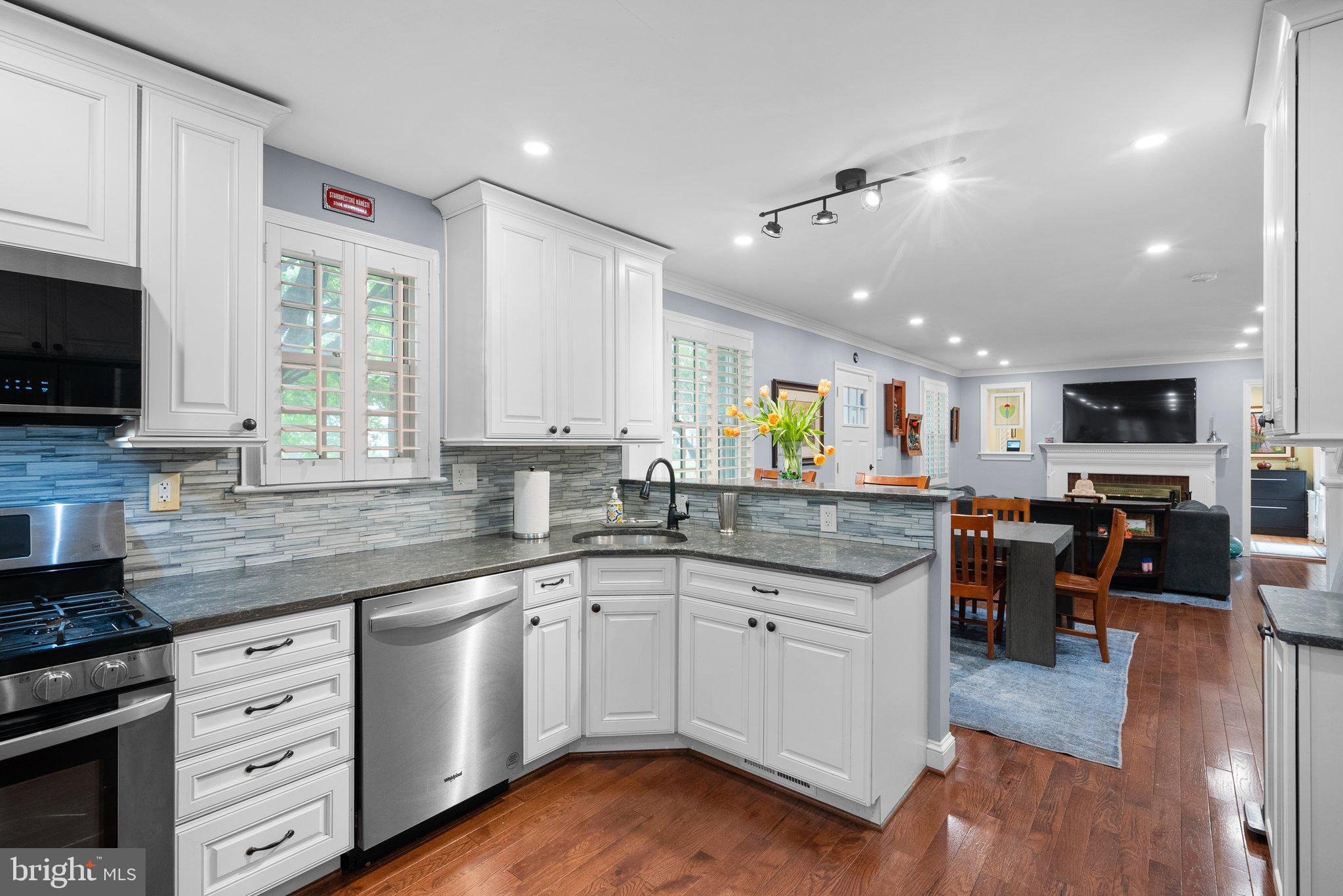 9911 Edgehill Lane Silver Spring, MD 20901 - Photo 10 of 45 a kitchen with stainless steel appliances granite countertop hardwood floor sink stove dining table and chairs