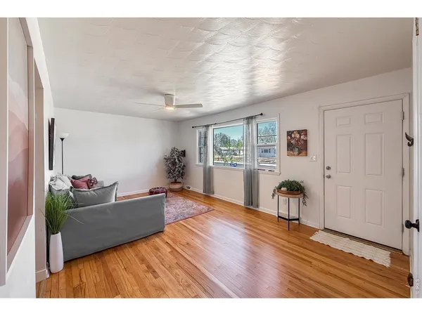 a living room with furniture and a wooden floor