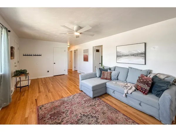 a living room with furniture and a wooden floor