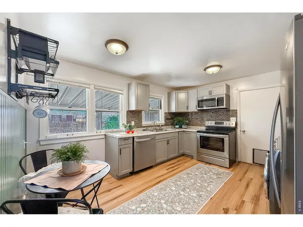 a kitchen with a refrigerator and a stove top oven