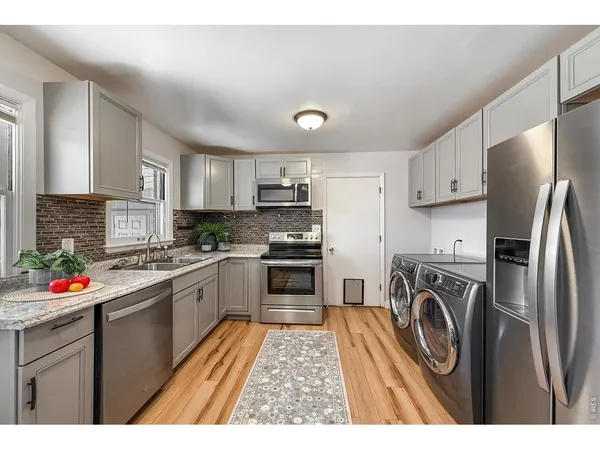 a kitchen with stainless steel appliances granite countertop a refrigerator stove and sink