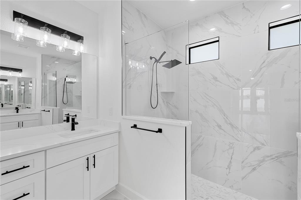 2805 Anniston Road North Port, FL 34288 - Photo 15 of 24 a bathroom with a double vanity sink mirror and shower