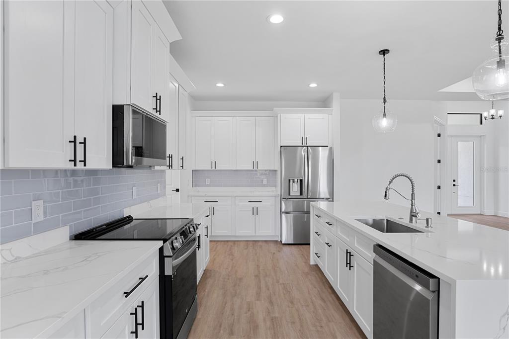 2805 Anniston Road North Port, FL 34288 - Photo 7 of 24 a kitchen with a sink stove a refrigerator and cabinets