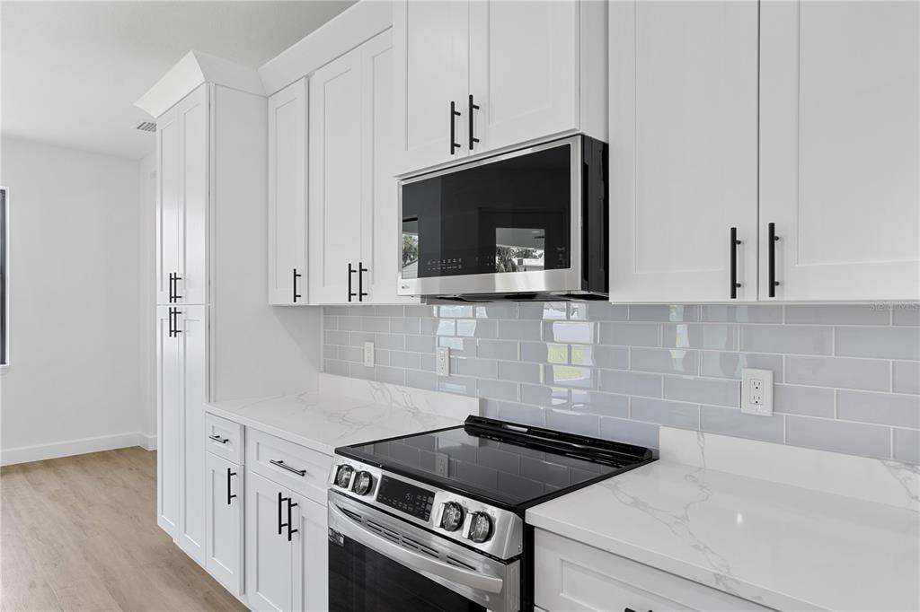 2805 Anniston Road North Port, FL 34288 - Photo 8 of 24 a kitchen with granite countertop a stove and a microwave