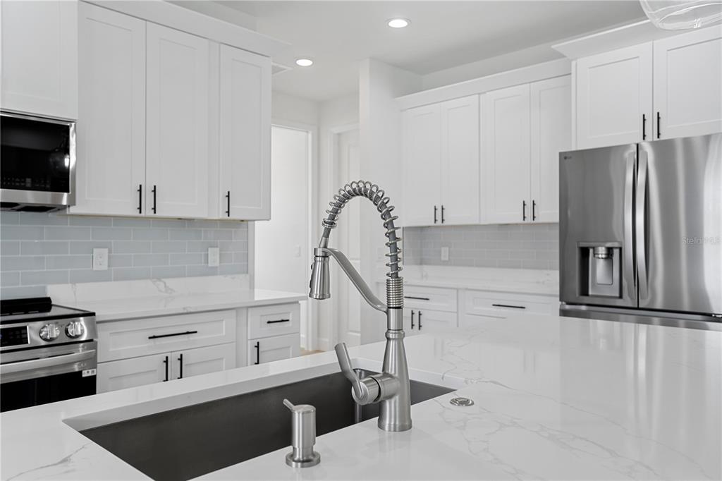 2805 Anniston Road North Port, FL 34288 - Photo 9 of 24 a kitchen with stainless steel appliances granite countertop a refrigerator and a stove top oven