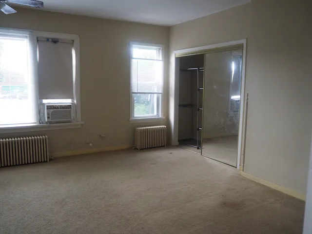 an empty room with windows and closet