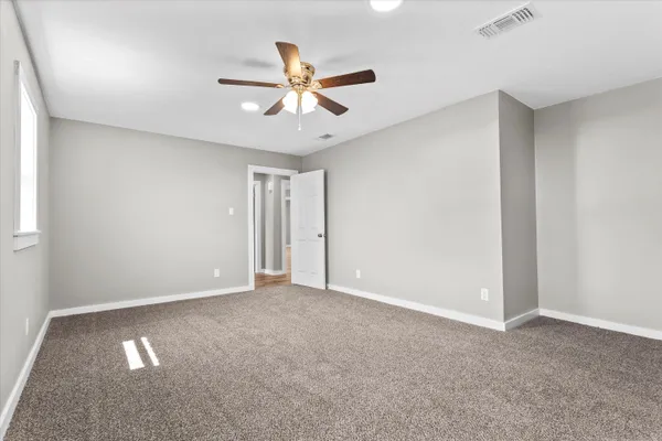 a view of an empty room with a ceiling fan