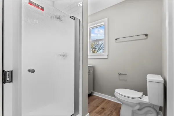 a white toilet sitting next to a shower