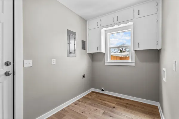 a view of small space with wooden floor and a window