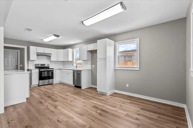 a kitchen with a refrigerator and white cabinets